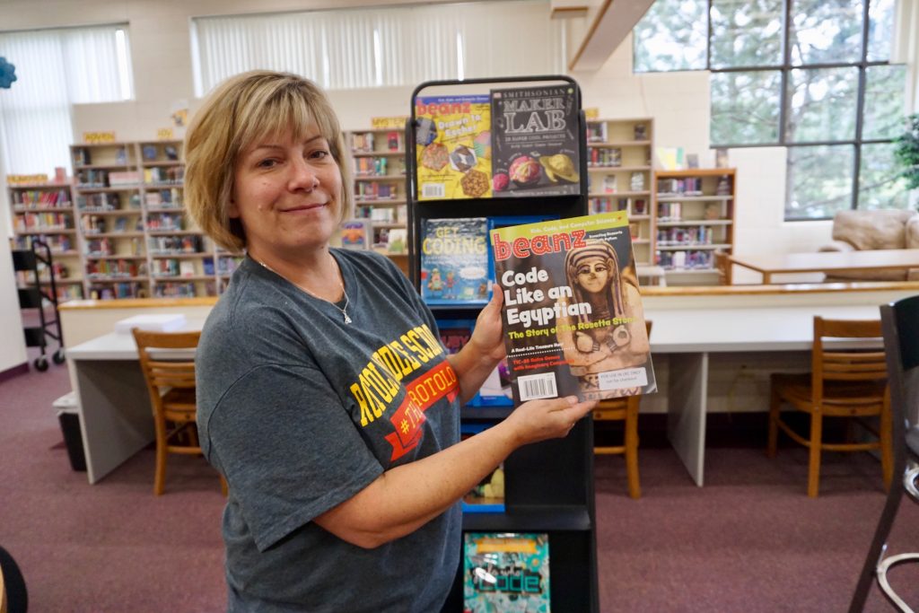 Rotolo Middle School LRC Director Kelly Cook by the STEM-related reading selections in the Fab Lab.